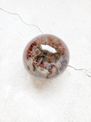 large resin ball with red, blue, gray ink swirls. Top View