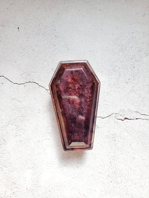 A resin made dice coffin, closed lid, in shimmering browns and blacks