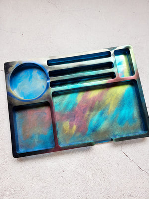 Top view of the gaming tray. It has a circle cubby, large rectangular cubby, small and medium rectangular cubbies, and three long spaces. The design is colorful micas creating a galaxy of reds, blues, greens, golds.