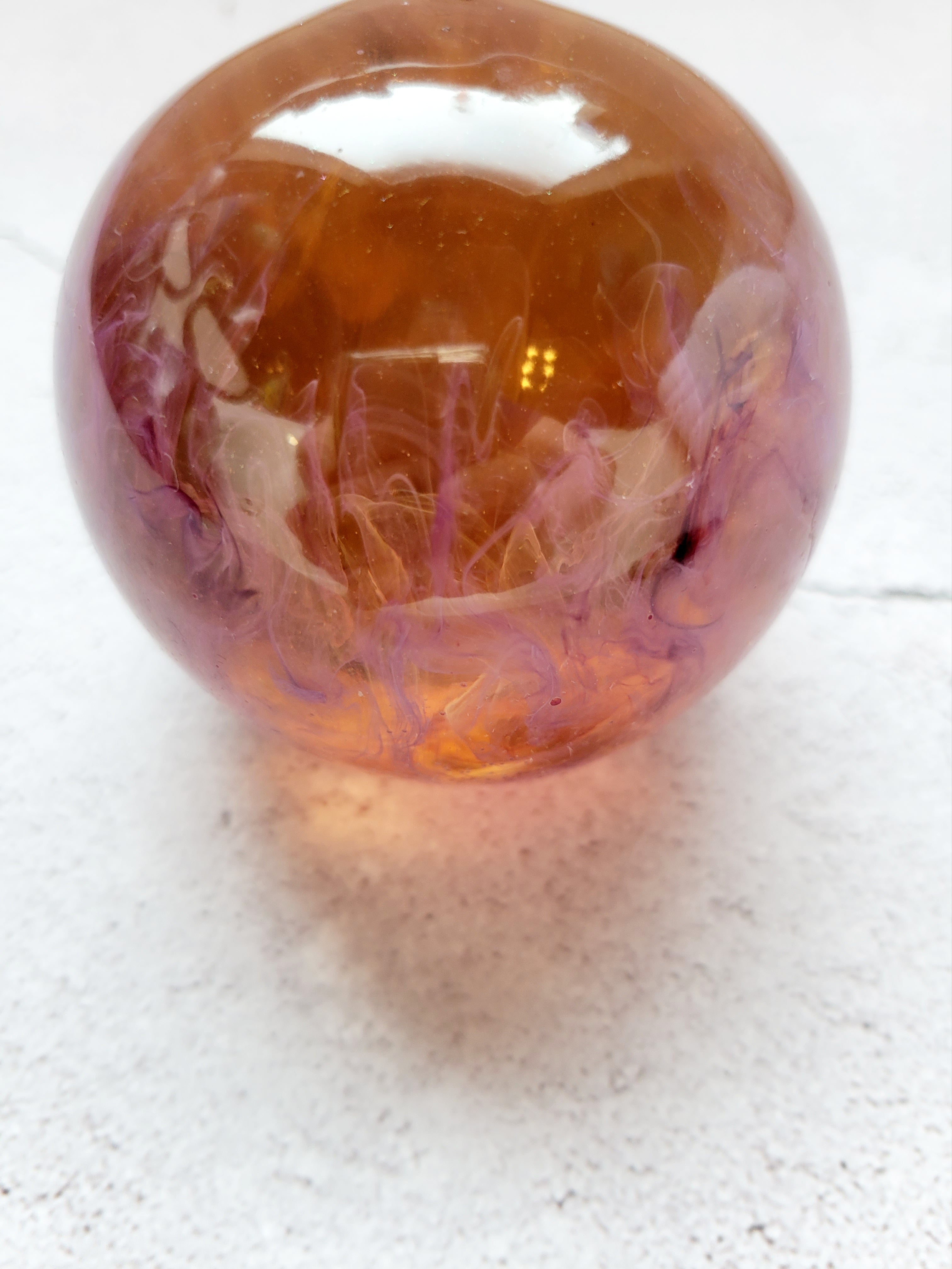 large resin ball with yellow and purple ink swirls. Side View
