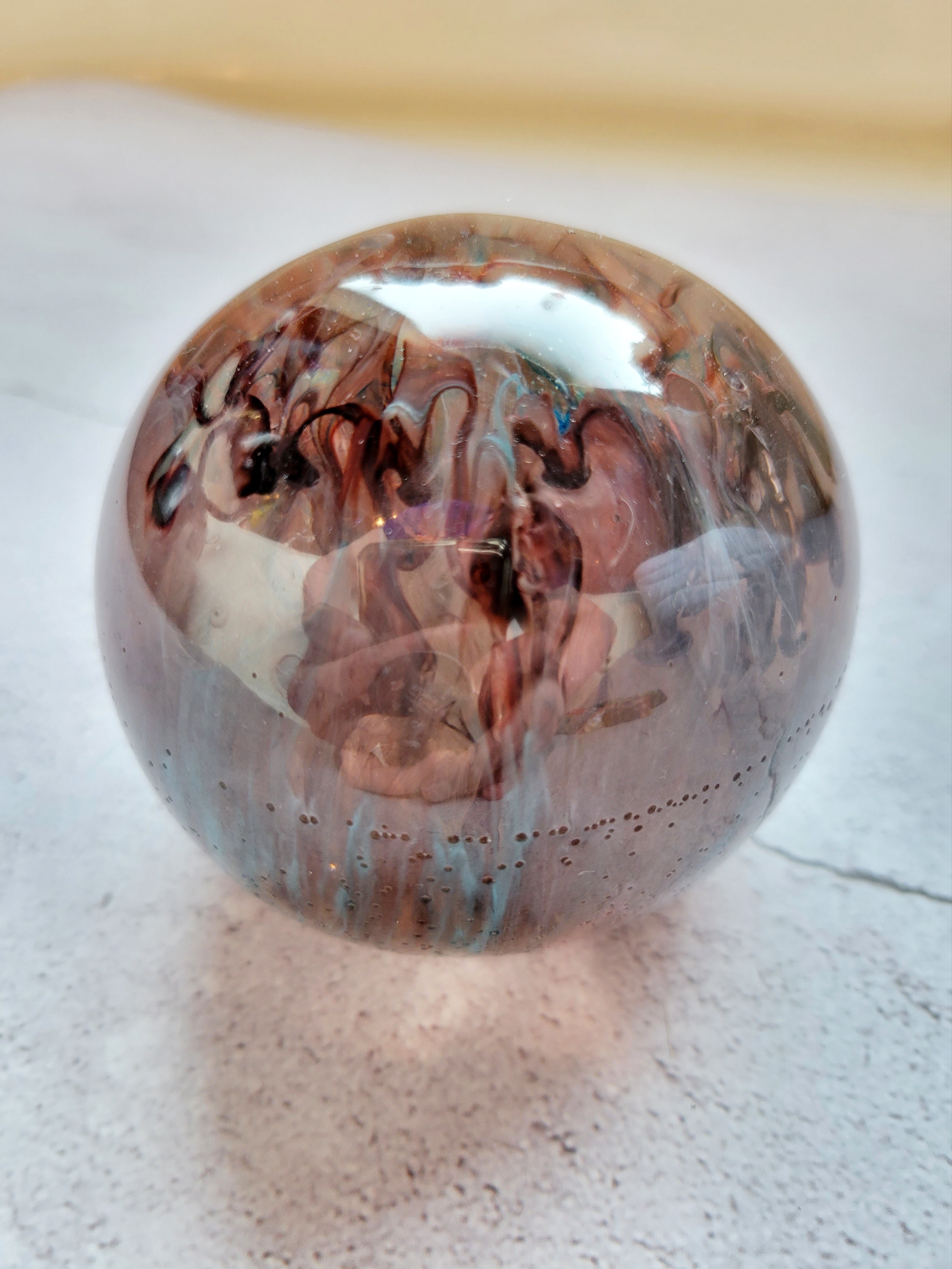 large resin ball with red, blue, gray ink swirls. Side View