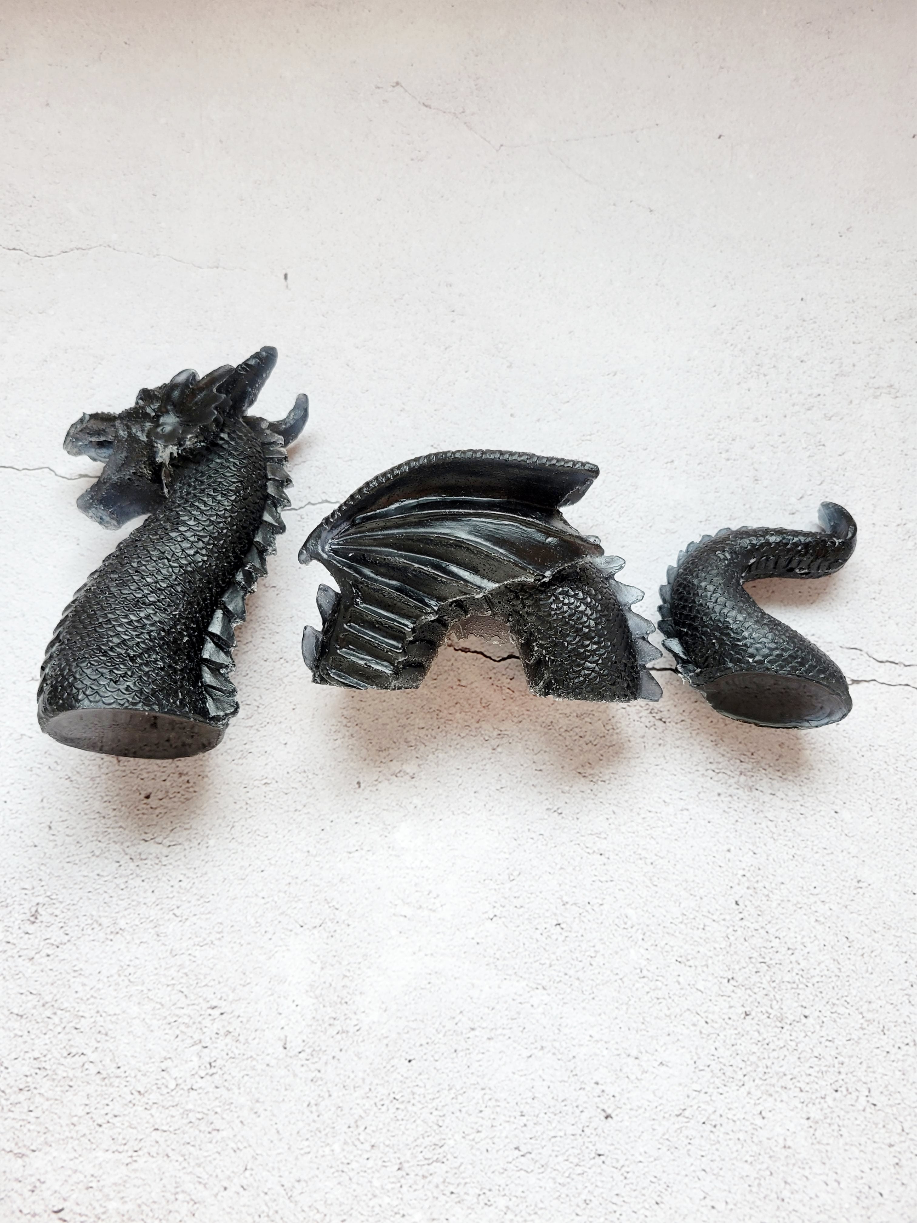 three piece resin sea serpent - Head, winged body, curved tail are all black. Top view of it laying on its side