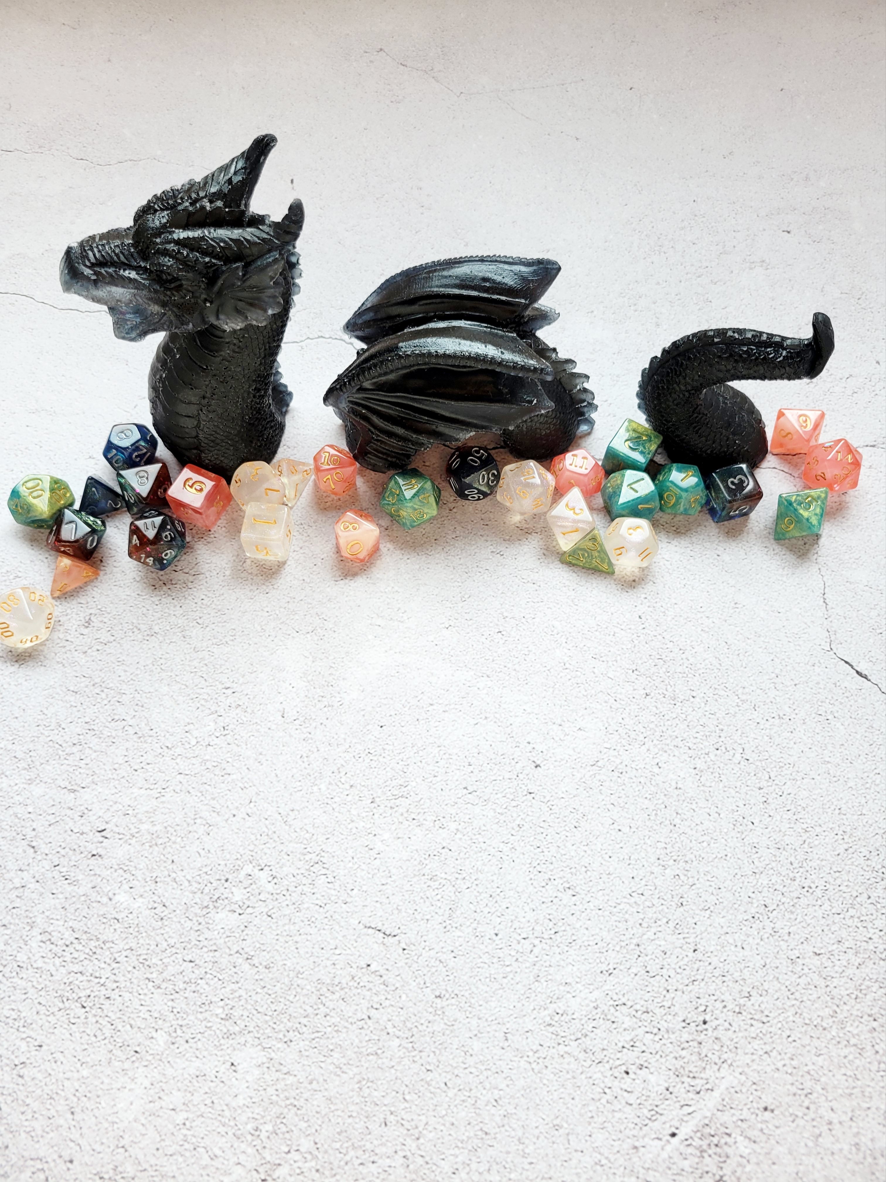 three piece resin sea serpent - Head, winged body, curved tail are all black. Front view surrounded by dice