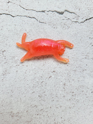 A small sleeping cat figure with painted face and paws. It's orange in color.