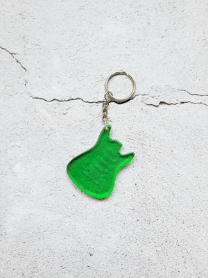 A birds eye view of a keychain in the style of an electric guitar body, no neck. It's green with fine silver glitter throughout. It has a silver chain and hoop.