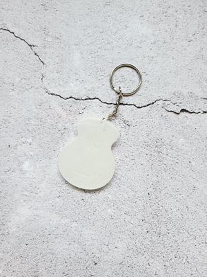 A white acoustic guitar body keychain with silver chain and hoop