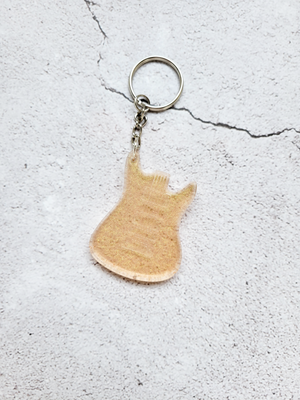 An electric guitar body keychain with a silver chain and ring hoop. It's a glittery gold color.