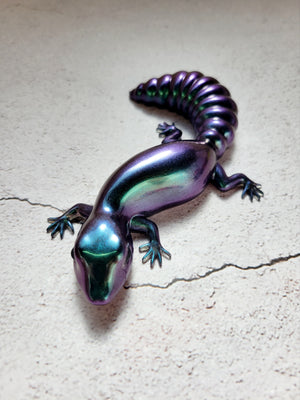 a resin made lizard in color shifting colors of shimmering blues, purples, greens. with black painted eyes. front view