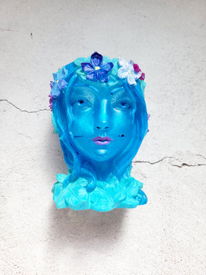 a resin made female ancient statue bust, blue in color with painted leaves and flowers. front view